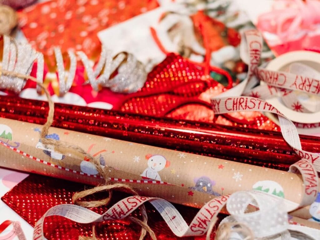 Christmas wrapping supplies including red ribbons and decorative paper