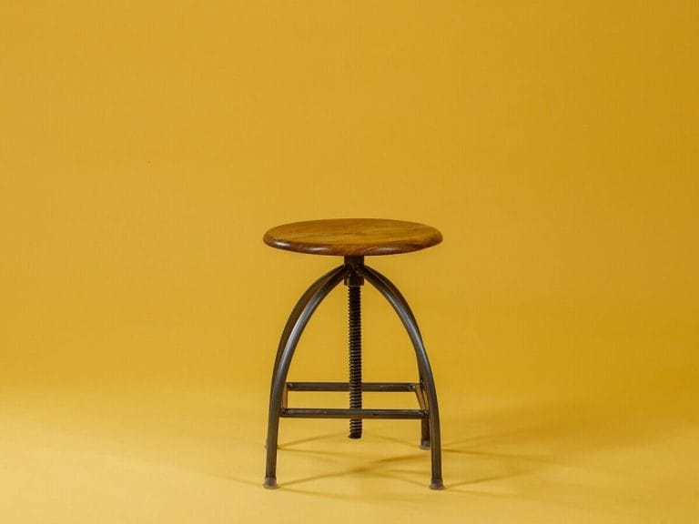 Minimalist wooden stool on yellow background