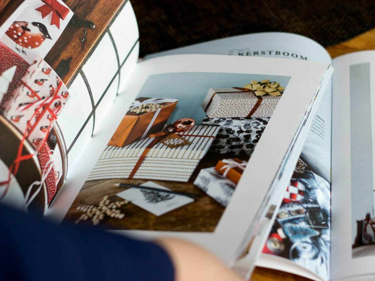 Flatlay of a magazine showing stylish wrapped gifts and holiday decor inspiration, perfect for identifying home decor preferences