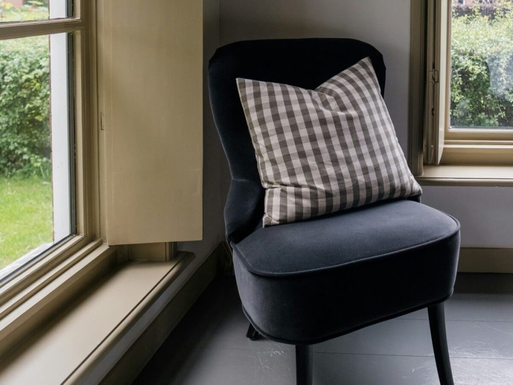 Chair placed at an angle near two windows illustrating angled layout