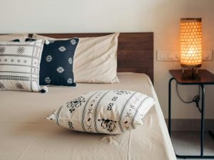 Small bedroom with bed pushed against wall and accent pillows