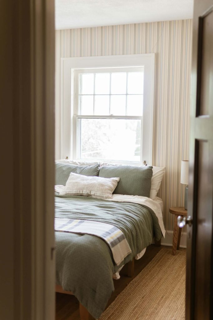 Small apartment bedroom furniture with jute rug and linen blanket