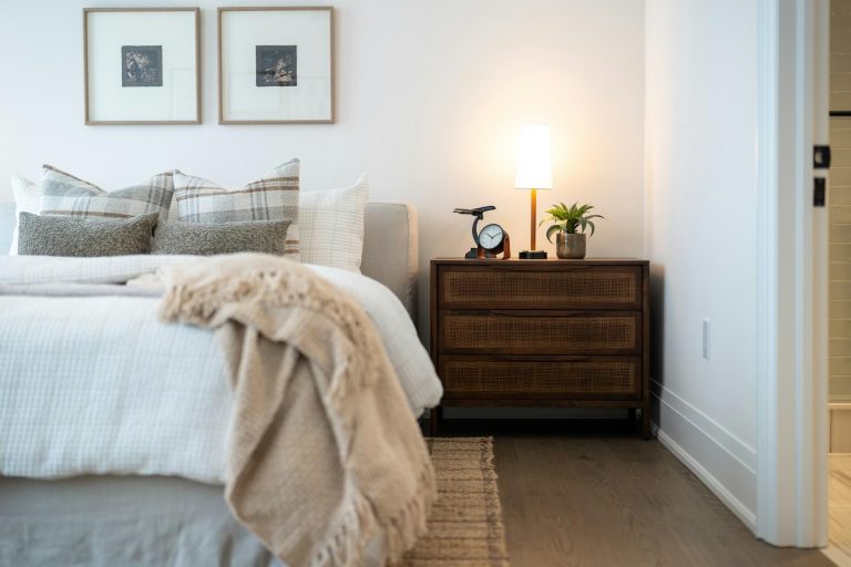 A modern bedroom with a dark wooden bedside table